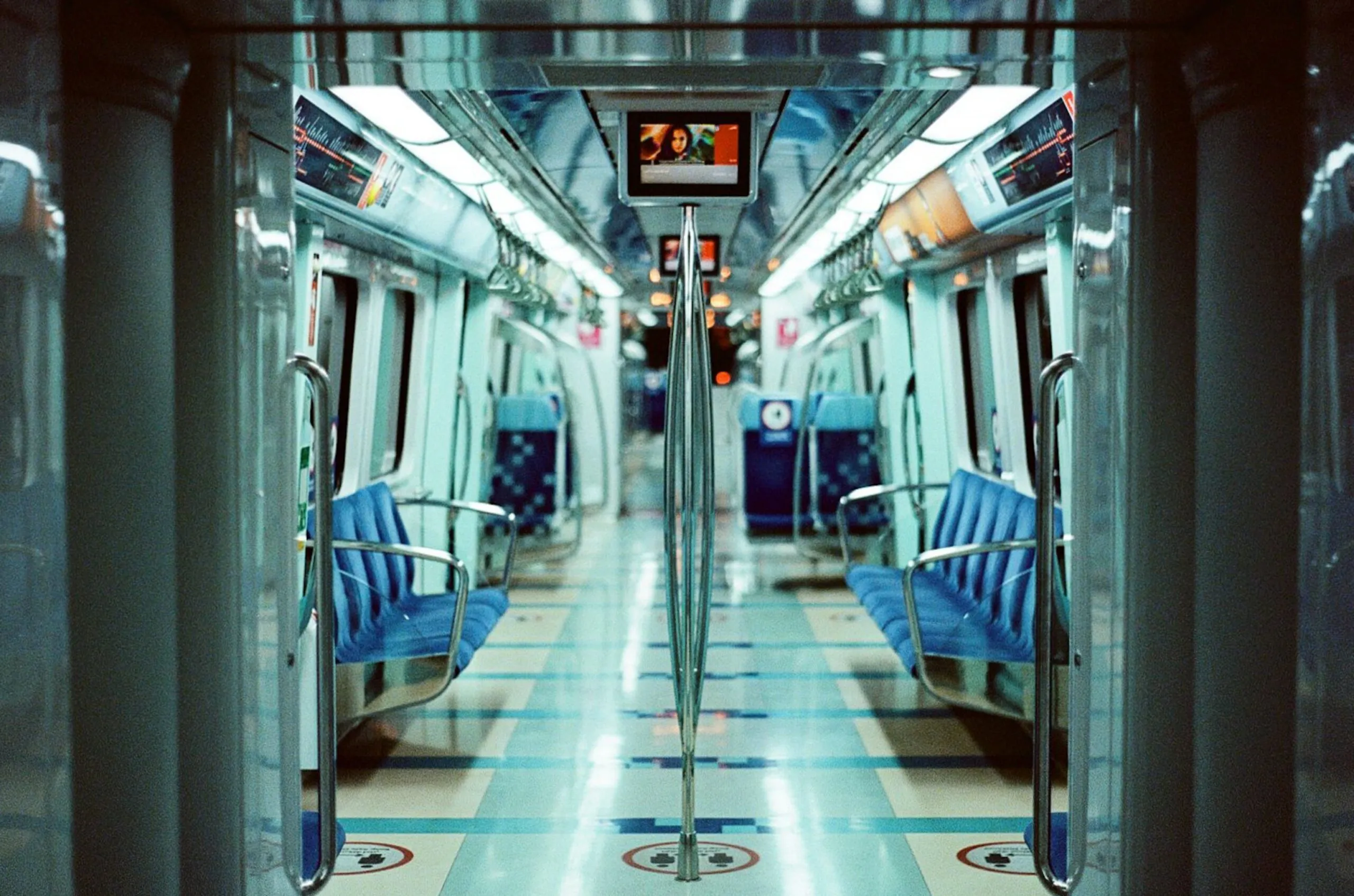 The picture shows the modern, driverless interior of a Dubai Metro train with its typical blue seats, complementing the Dubai metro station map.