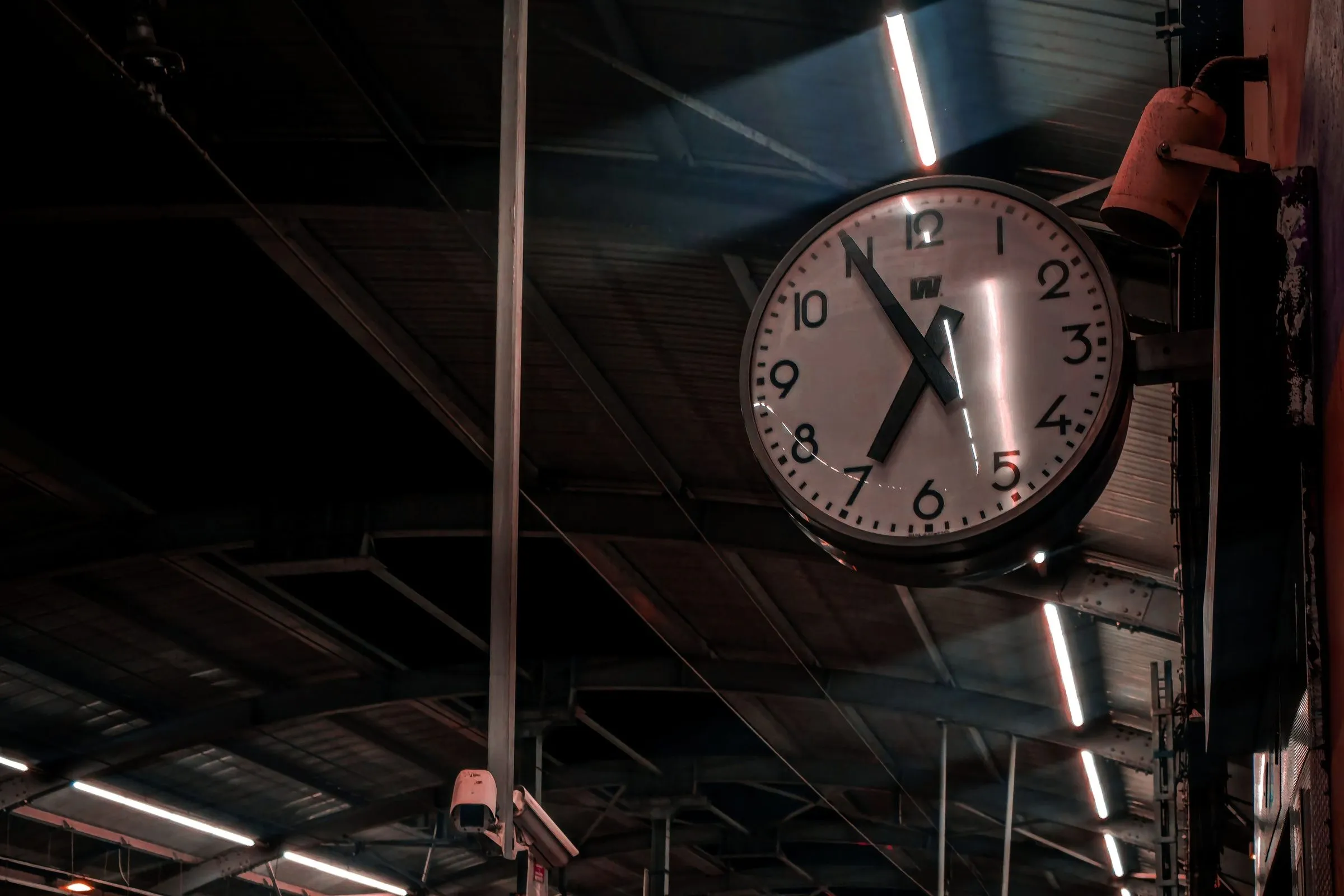 Eine große Stationsuhr hängt über einem ruhigen Bahnsteig und verweist auf den Fahrplan der Metro in Hyderabad.