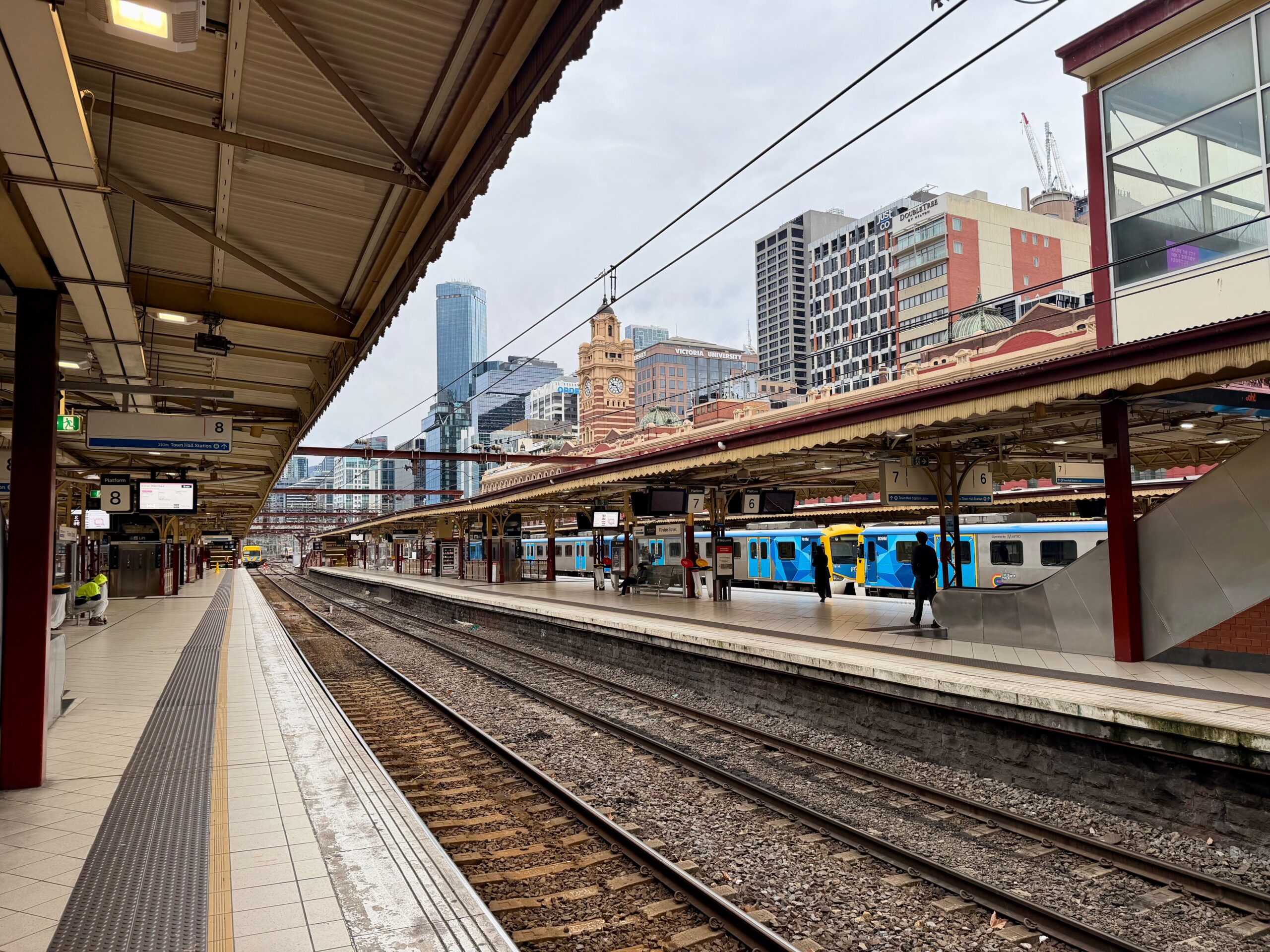 The platforms, clocks and blue commuter trains at Flinders Street Station illustrate the Melbourne train network.