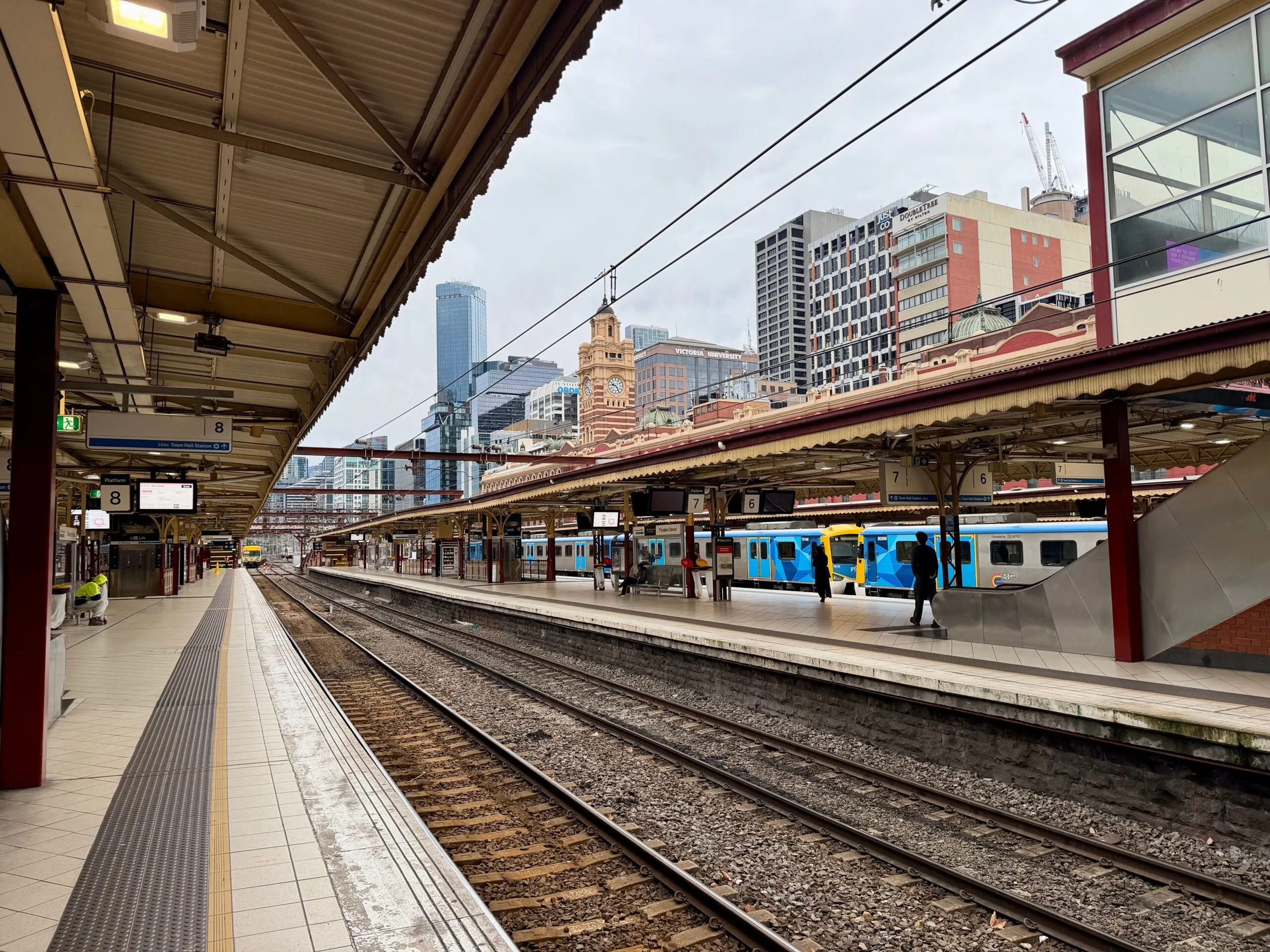 The platforms, clocks and blue commuter trains at Flinders Street Station illustrate the Melbourne train network.