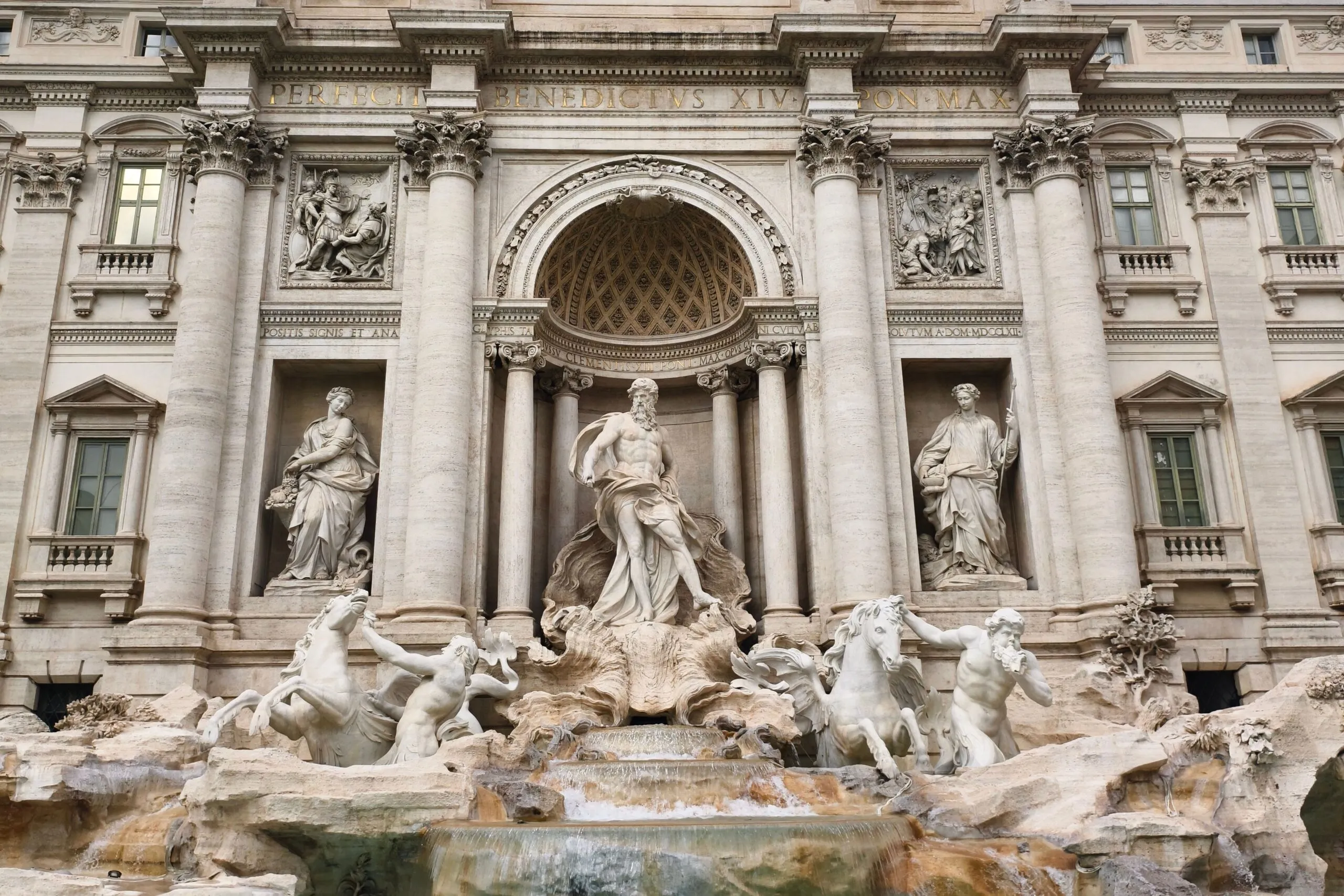 The image shows the Baroque Trevi Fountain and its Oceanus statue, one of the attractions travelers can reach using the Rome Metro.