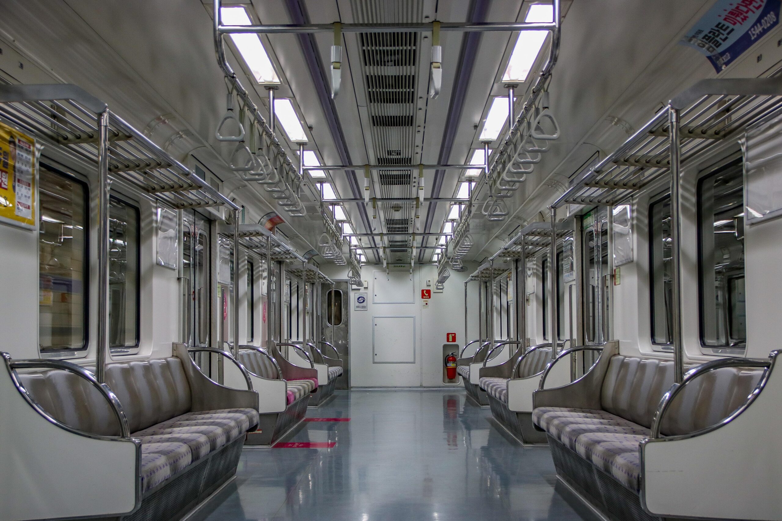 Ein leerer Zug der Seoul Metro auf Linie 5 zeigt Sitze und Halteschlaufen im Wageninneren.