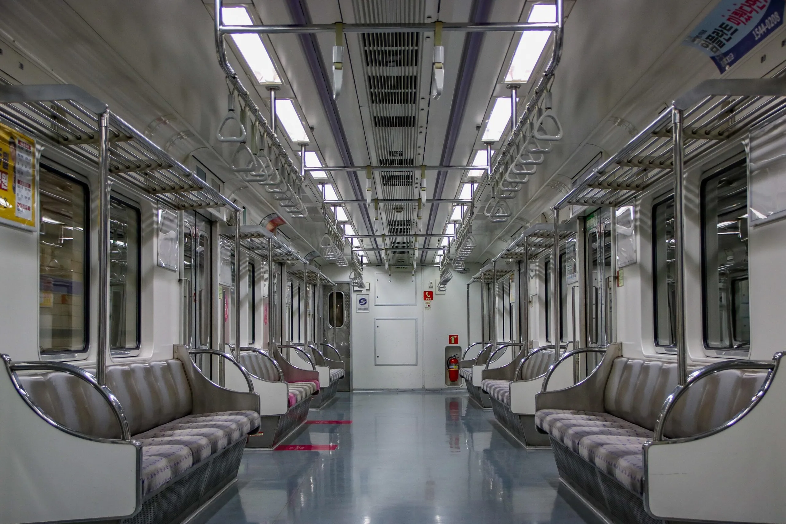 Ein leerer Zug der Seoul Metro auf Linie 5 zeigt Sitze und Halteschlaufen im Wageninneren.