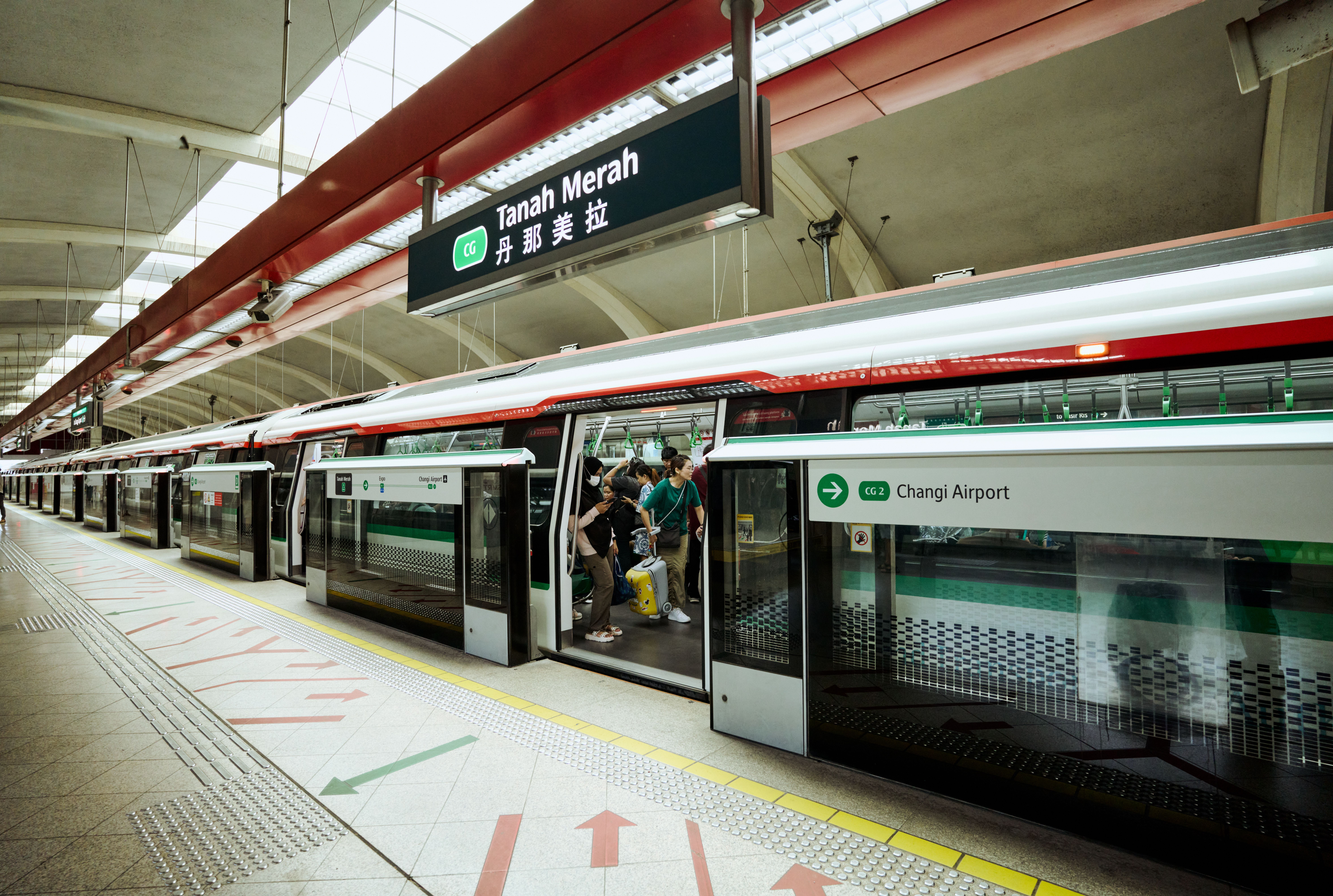 Auf dem Bild wartet ein Zug der MRT in Singapur an der Station Tanah Merah neben den Schildern zum Flughafen Changi.