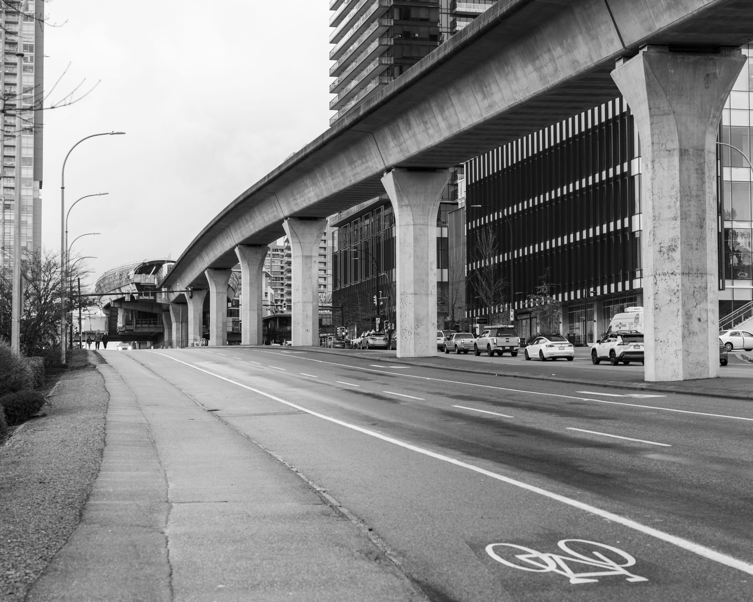 The image shows an elevated rapid transit viaduct running above a broad urban street.