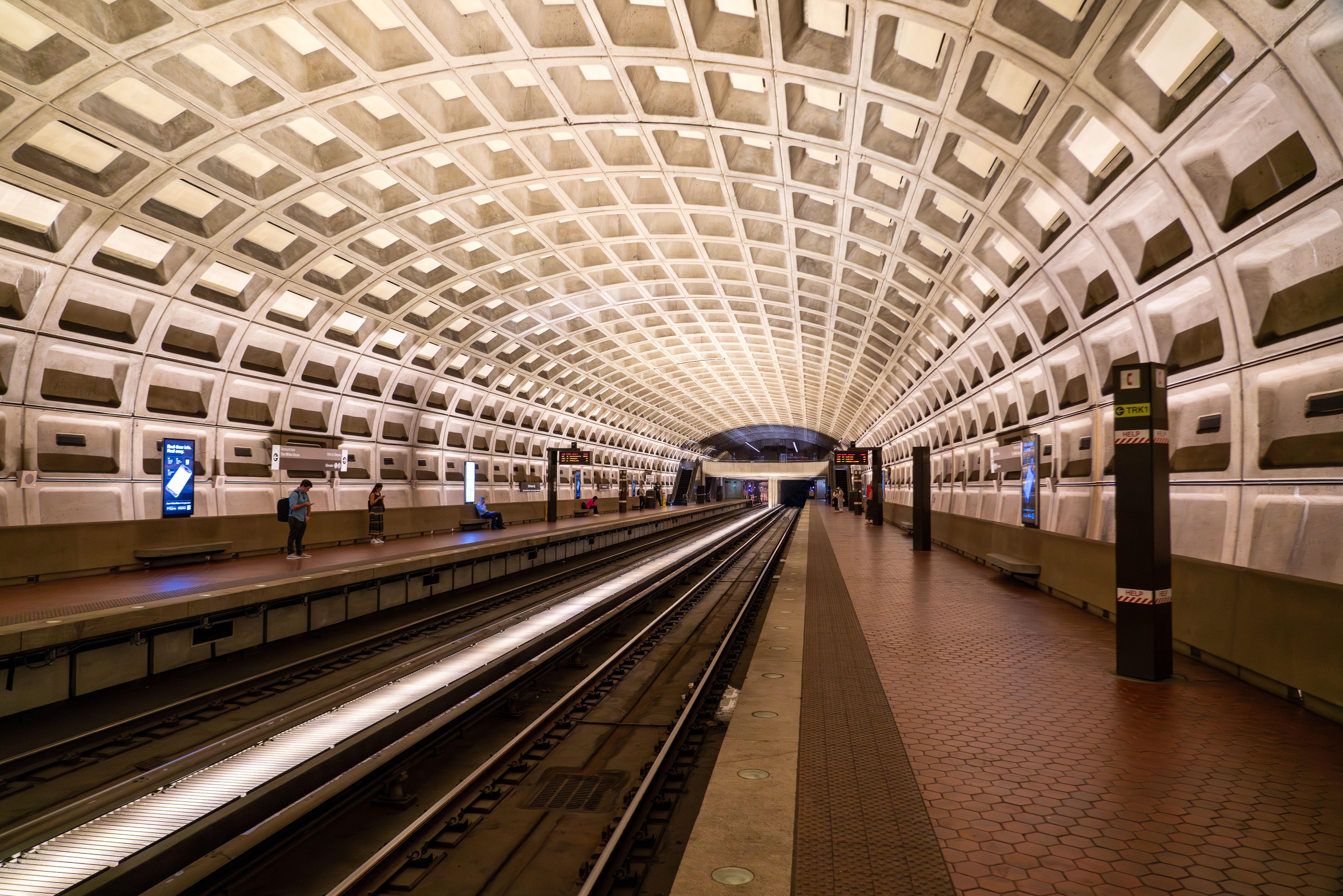 Auf dem Bild sehen Sie einen gewölbten Bahnsteig mit der markanten Kassettenarchitektur der Metro Washington DC.