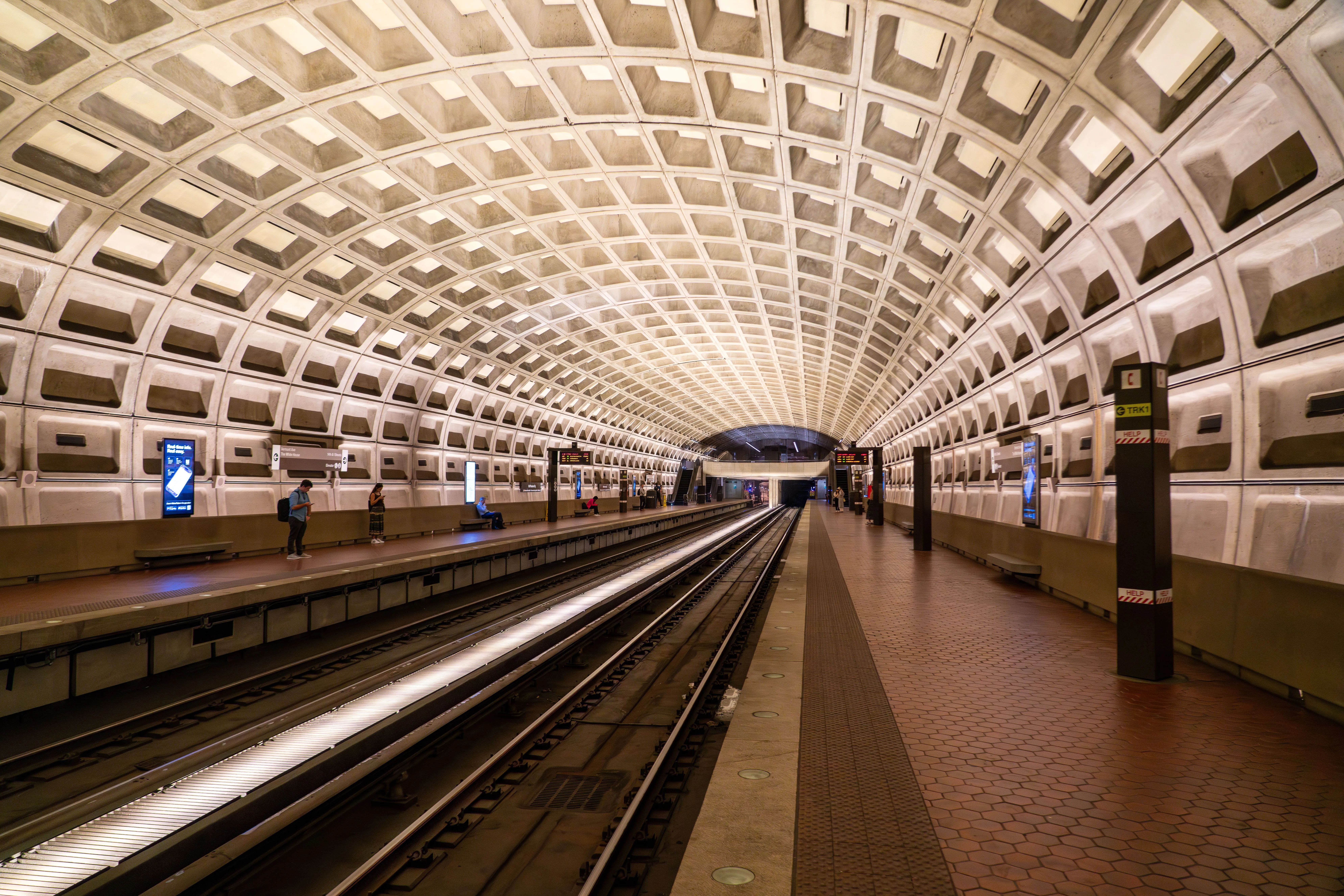 Auf dem Bild sehen Sie einen gewölbten Bahnsteig mit der markanten Kassettenarchitektur der Metro Washington DC.
