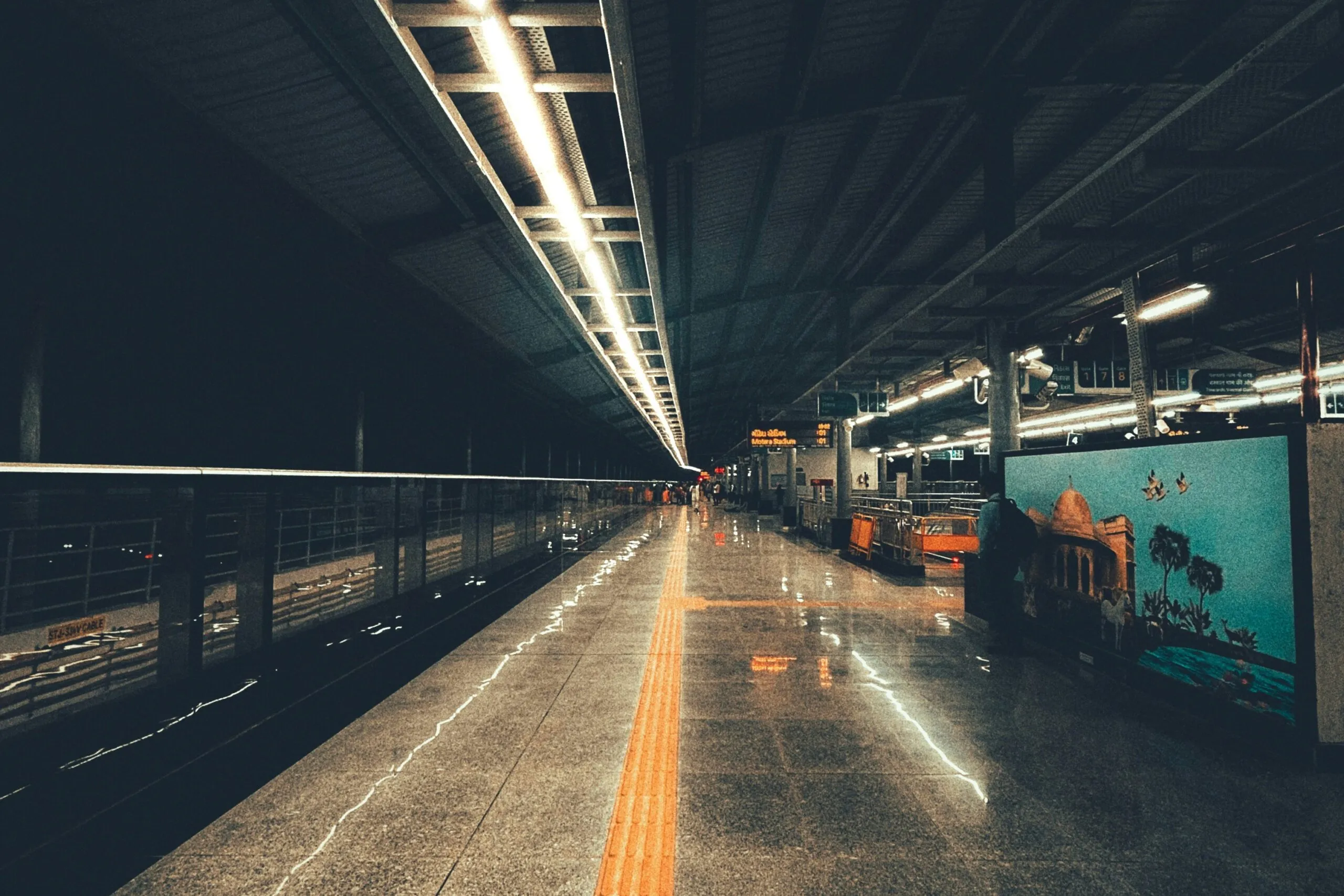 In der APMC Metro Station verläuft ein taktiler Leitweg über den beleuchteten Bahnsteig.
