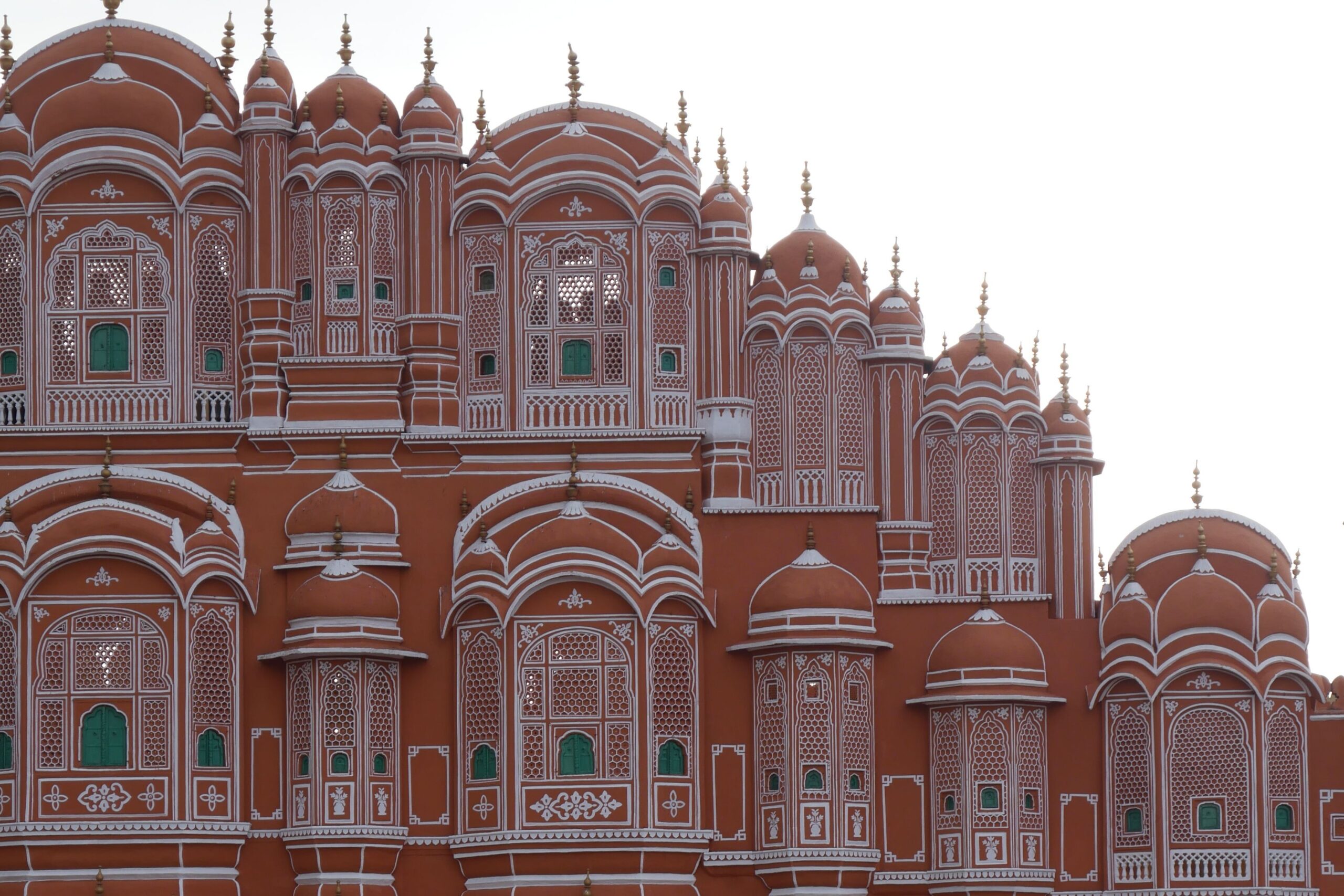 Auf dem Bild sieht man die Fassade des Hawa Mahal in Jaipurs Altstadt nahe der Station Badi Chaupar.