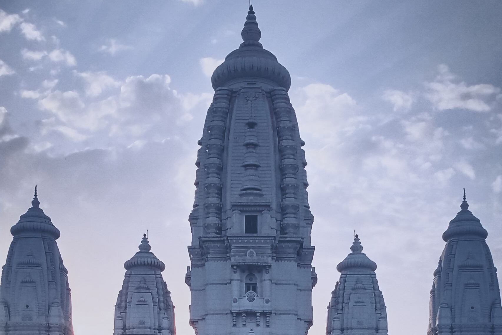 Hohe verzierte Türme des JK Temple in Kanpur über den umliegenden Bäumen.