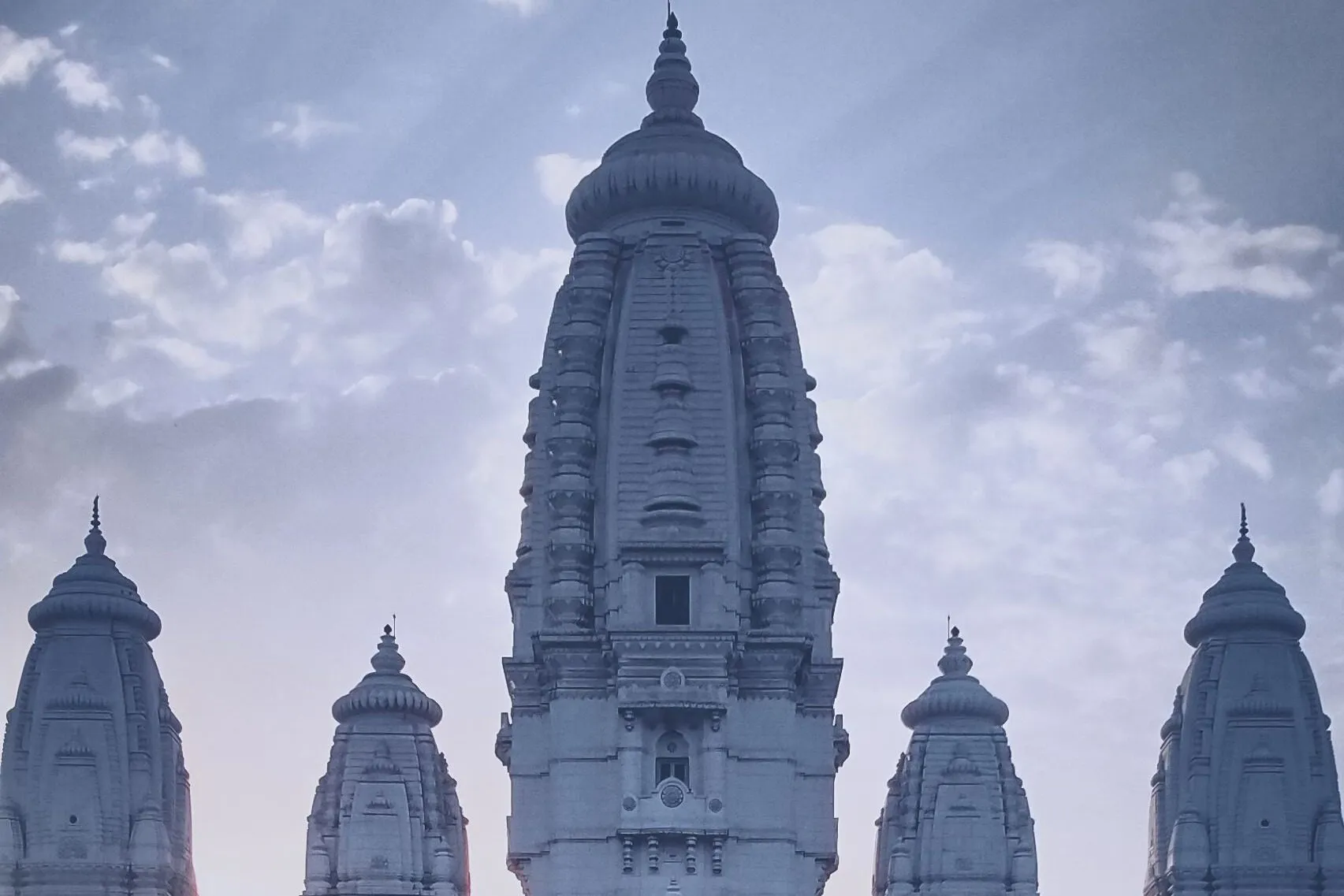 Hohe verzierte Türme des JK Temple in Kanpur über den umliegenden Bäumen.