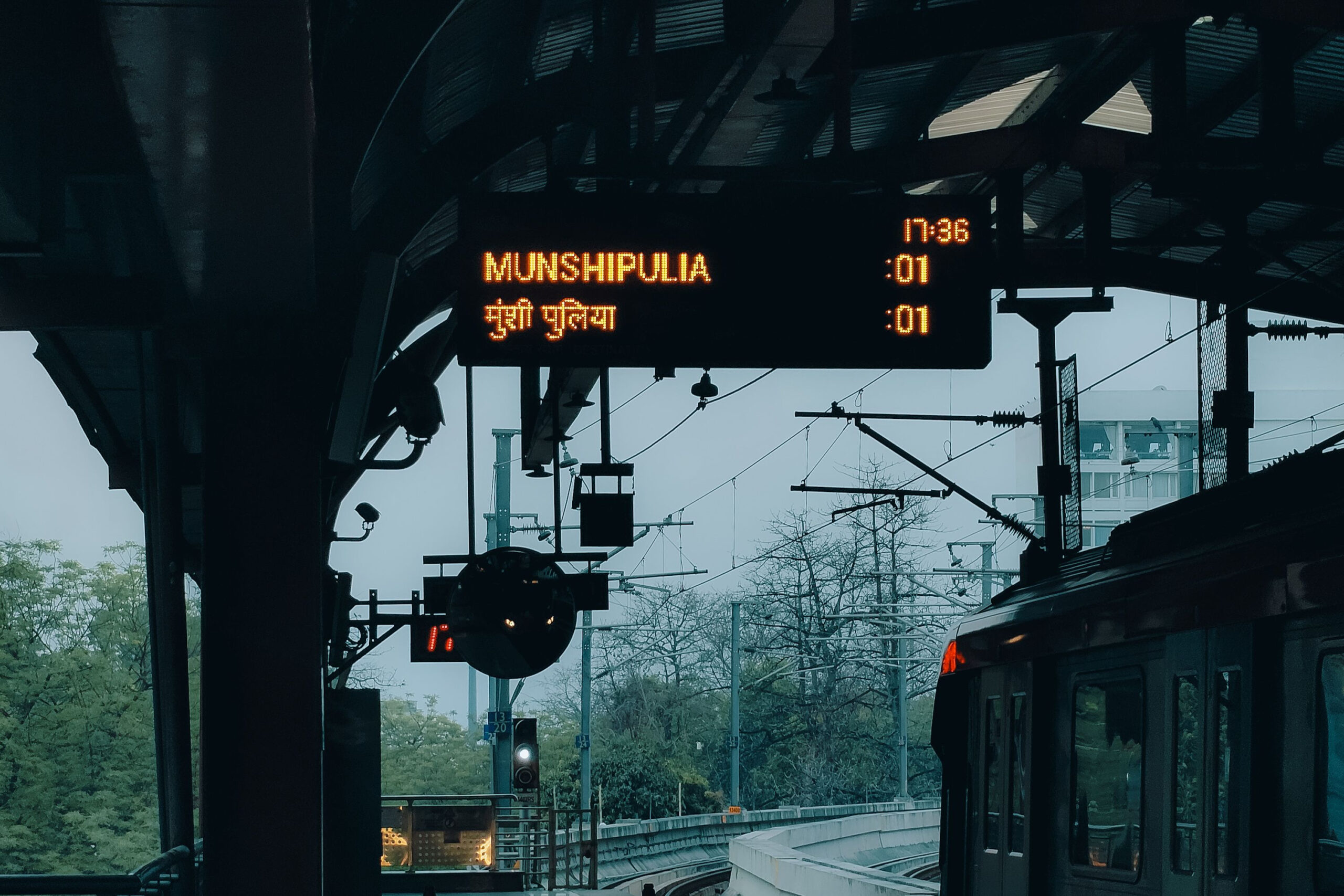 Ein Zug der Metro Lucknow steht am Bahnsteig, auf der Zielanzeige ist Munshipulia zu sehen.