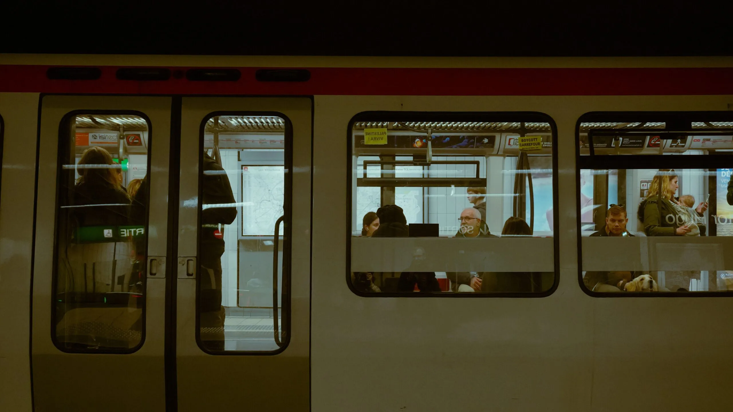 The image shows a Lyon Metro train at a platform with passengers visible through its windows.