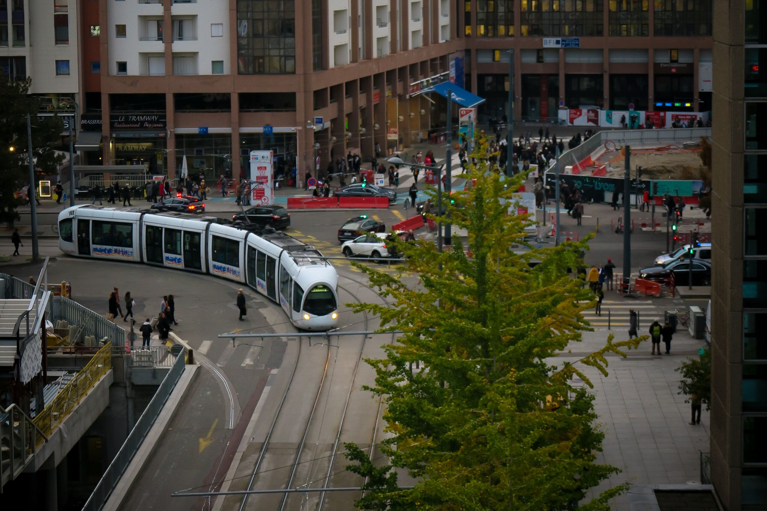 Eine Straßenbahn von TCL fährt über einen städtischen Platz in Lyon.