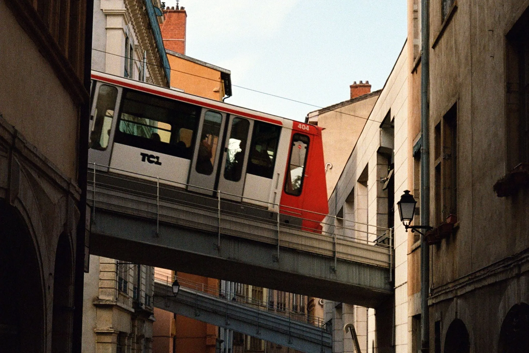 The image shows a TCL funicular crossing above a street in Vieux Lyon.