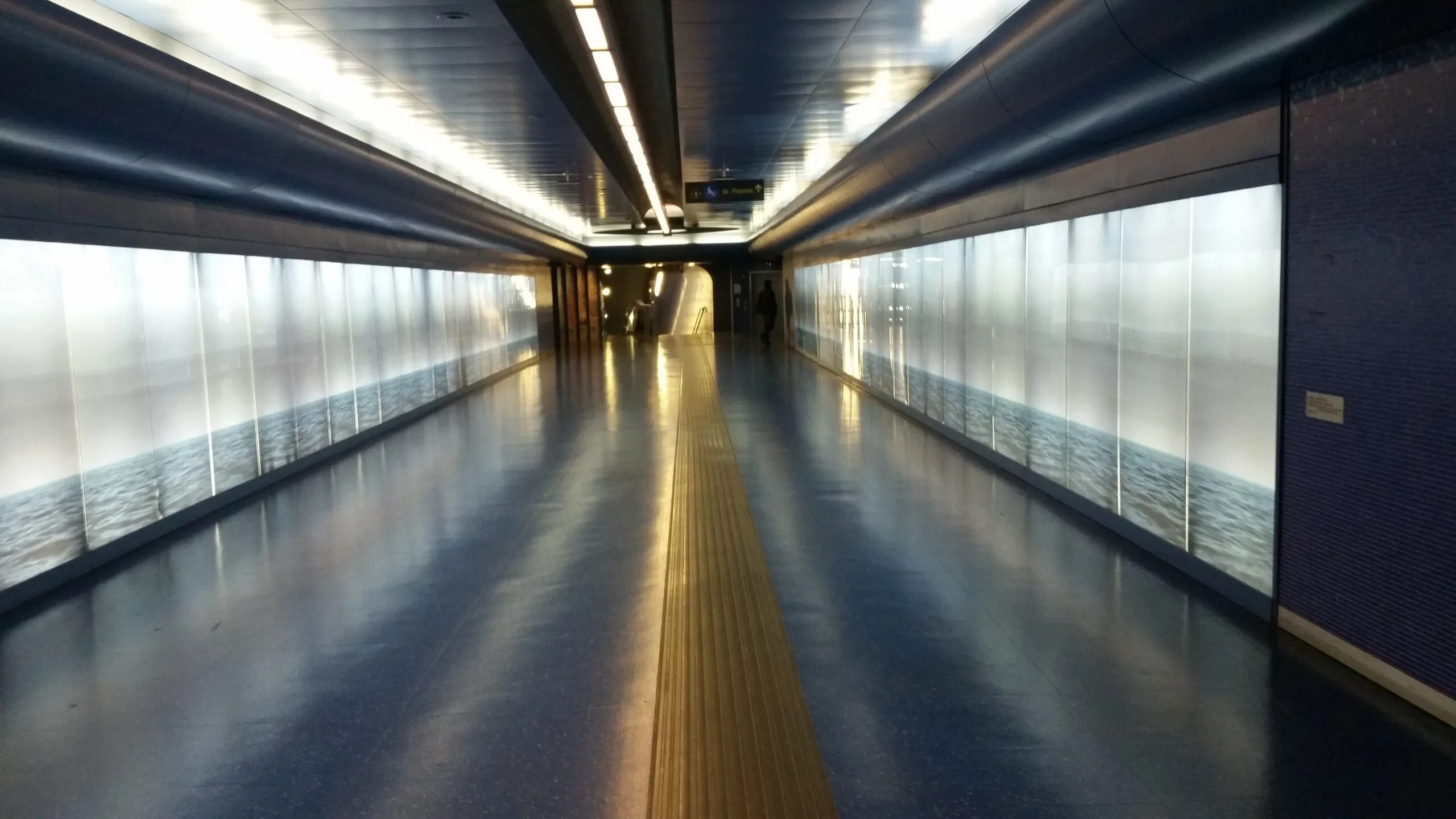Auf dem Bild ist ein beleuchteter Durchgang in einer Metrostation in Neapel zu sehen.
