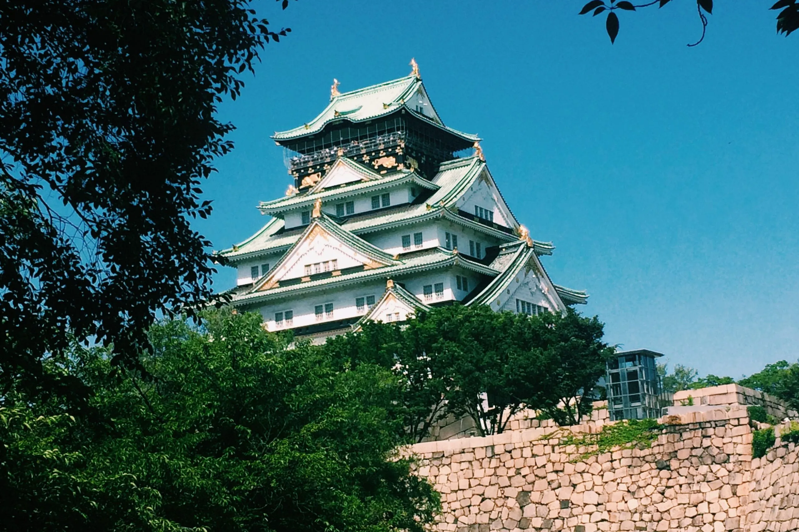 Das Schloss Osaka erhebt sich über den Bäumen nahe den Verbindungen der U-Bahn.
