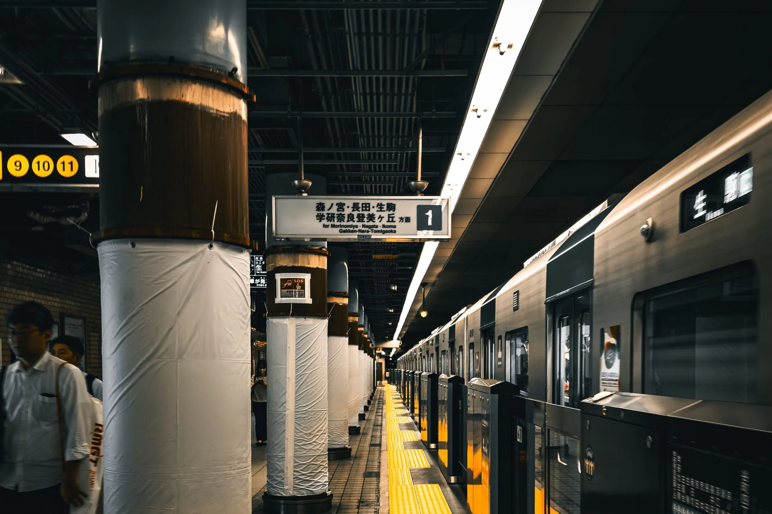 Ein Zug der Osaka Metro steht an einem Bahnsteig mit Wegweisern nach Morinomiya und Nagata.