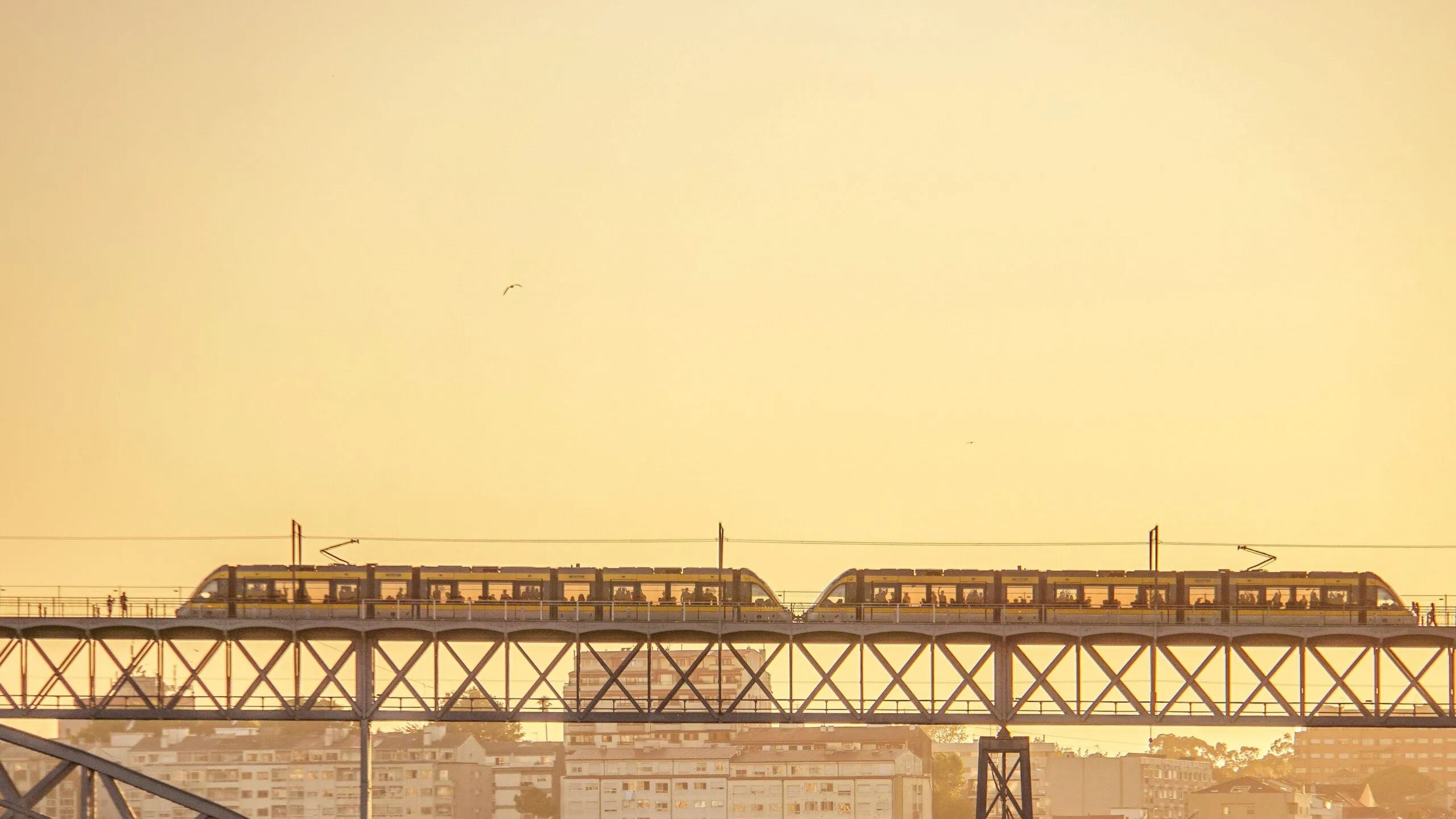 Ein Zug von Metro do Porto überquert bei Sonnenuntergang die obere Ebene der Ponte Dom Luís I.