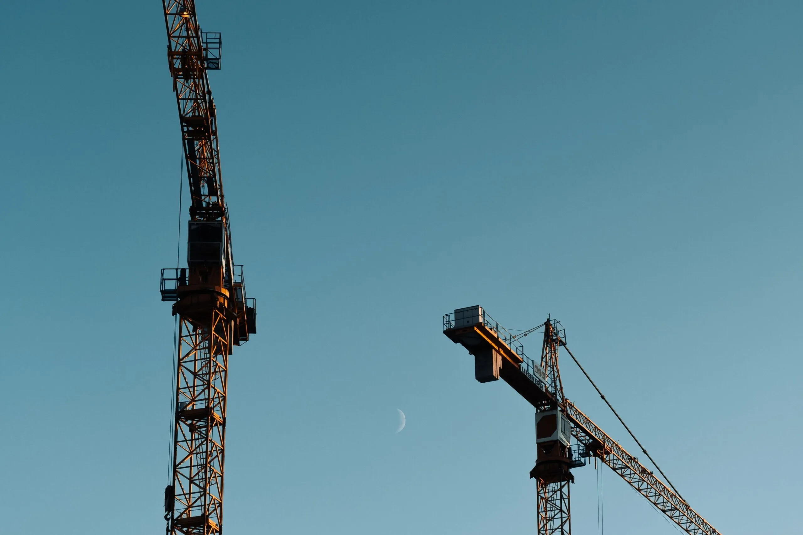 Two construction cranes illustrate the continuing Seville Metro Line 3 works.