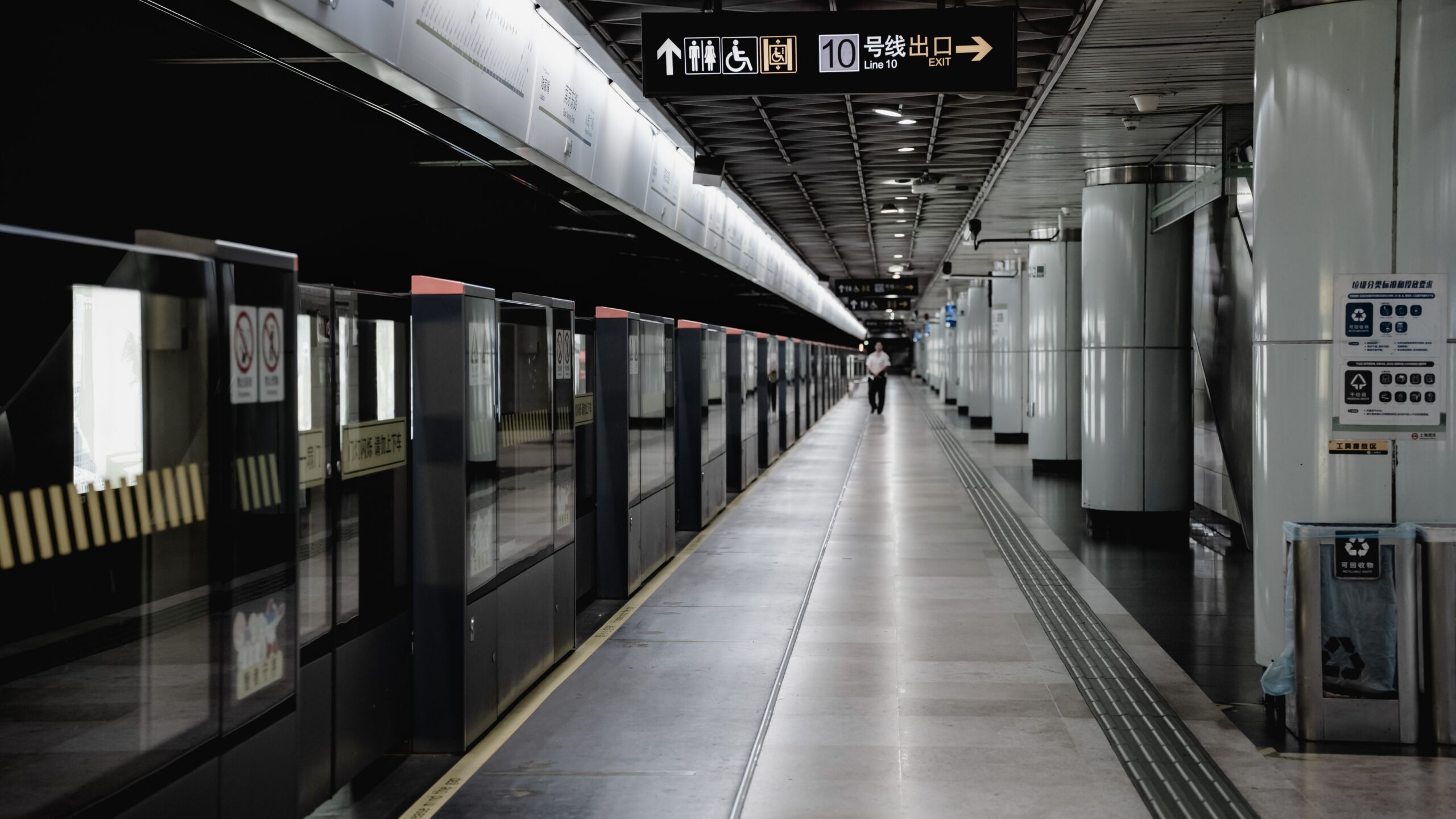 Ein ruhiger Bahnsteig der Linie 10 in Shanghai zeigt zweisprachige Wegweiser zu den Ausgängen.