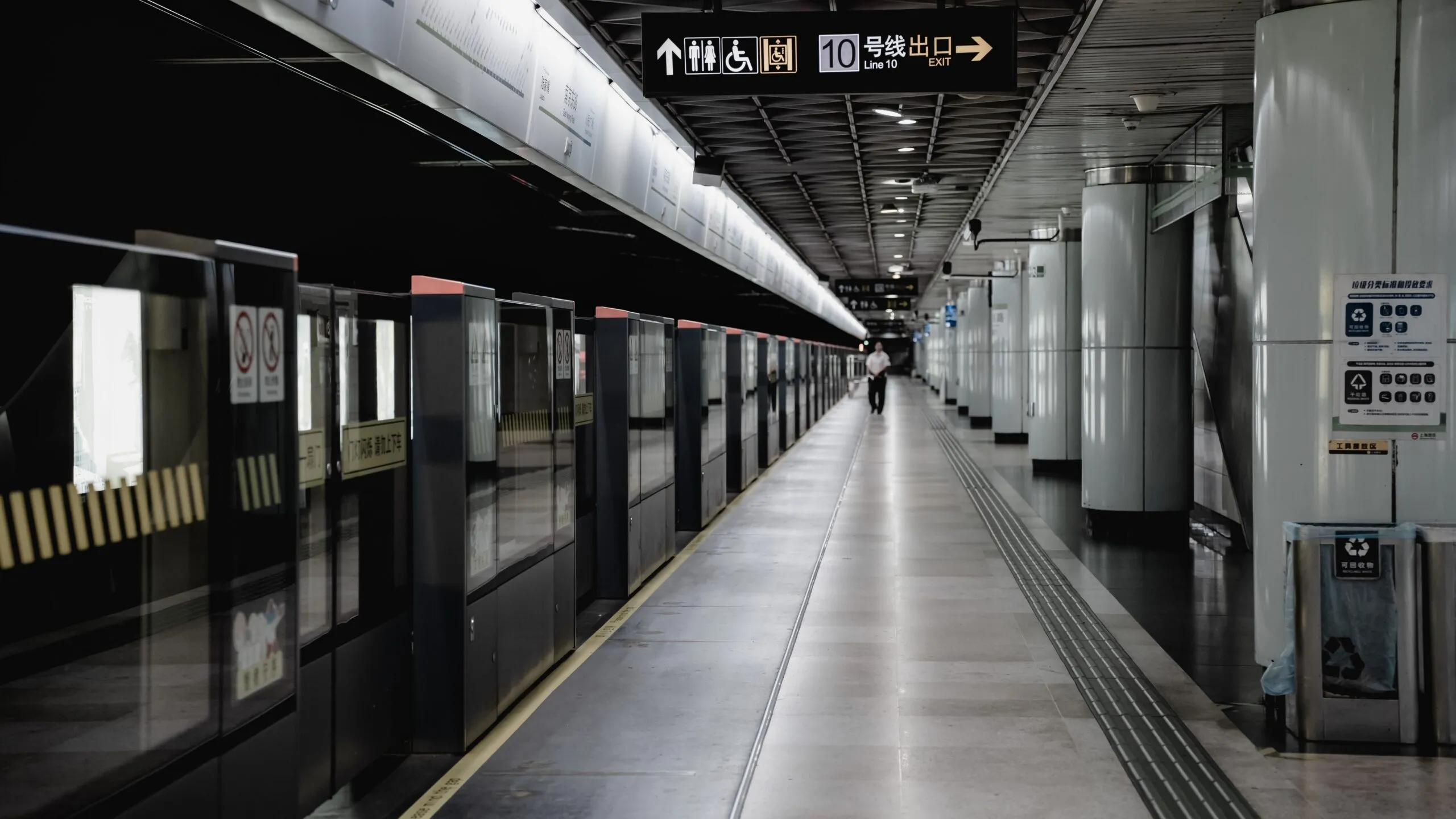 Ein ruhiger Bahnsteig der Linie 10 in Shanghai zeigt zweisprachige Wegweiser zu den Ausgängen.