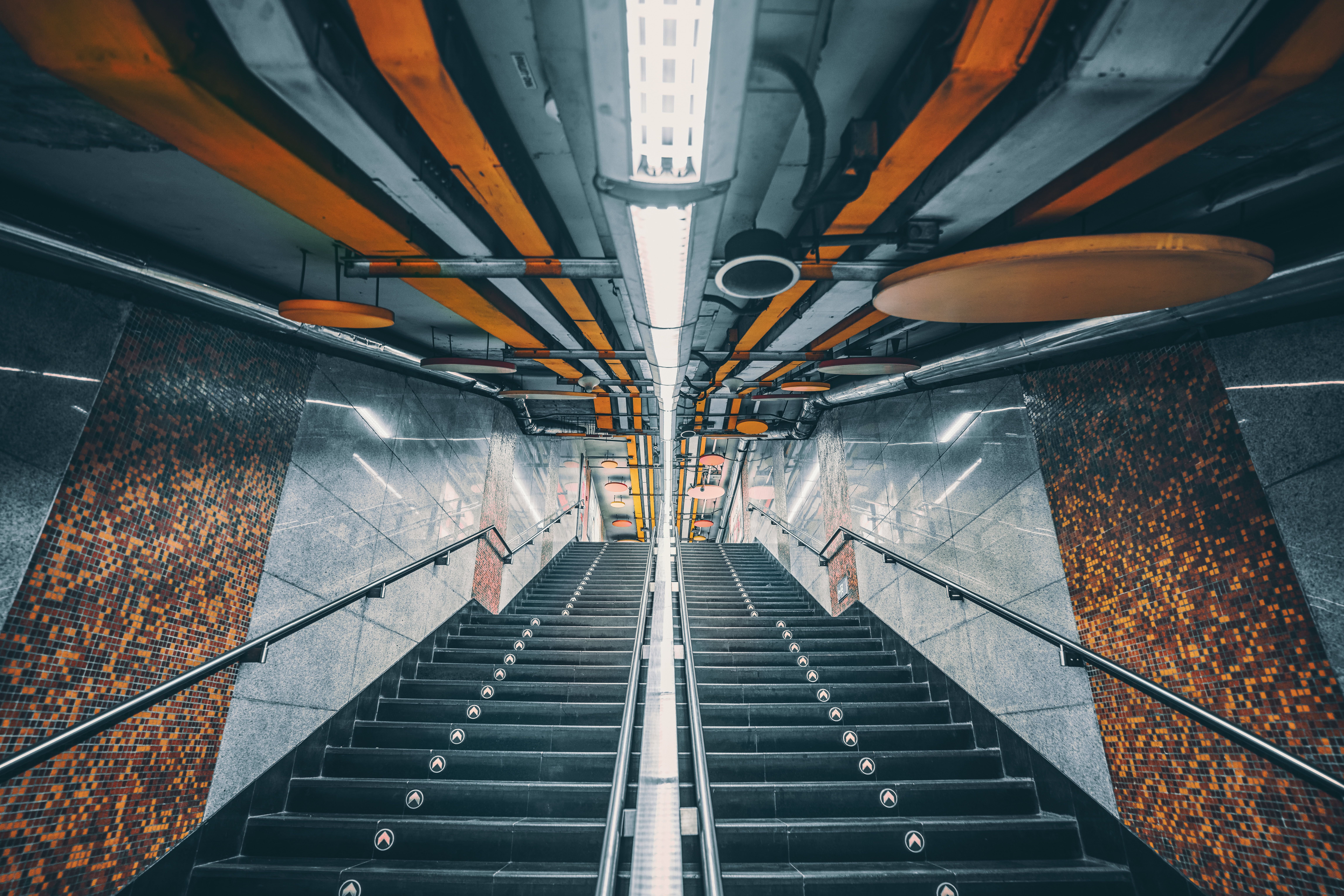 The image shows a geometric staircase inside a subway station.