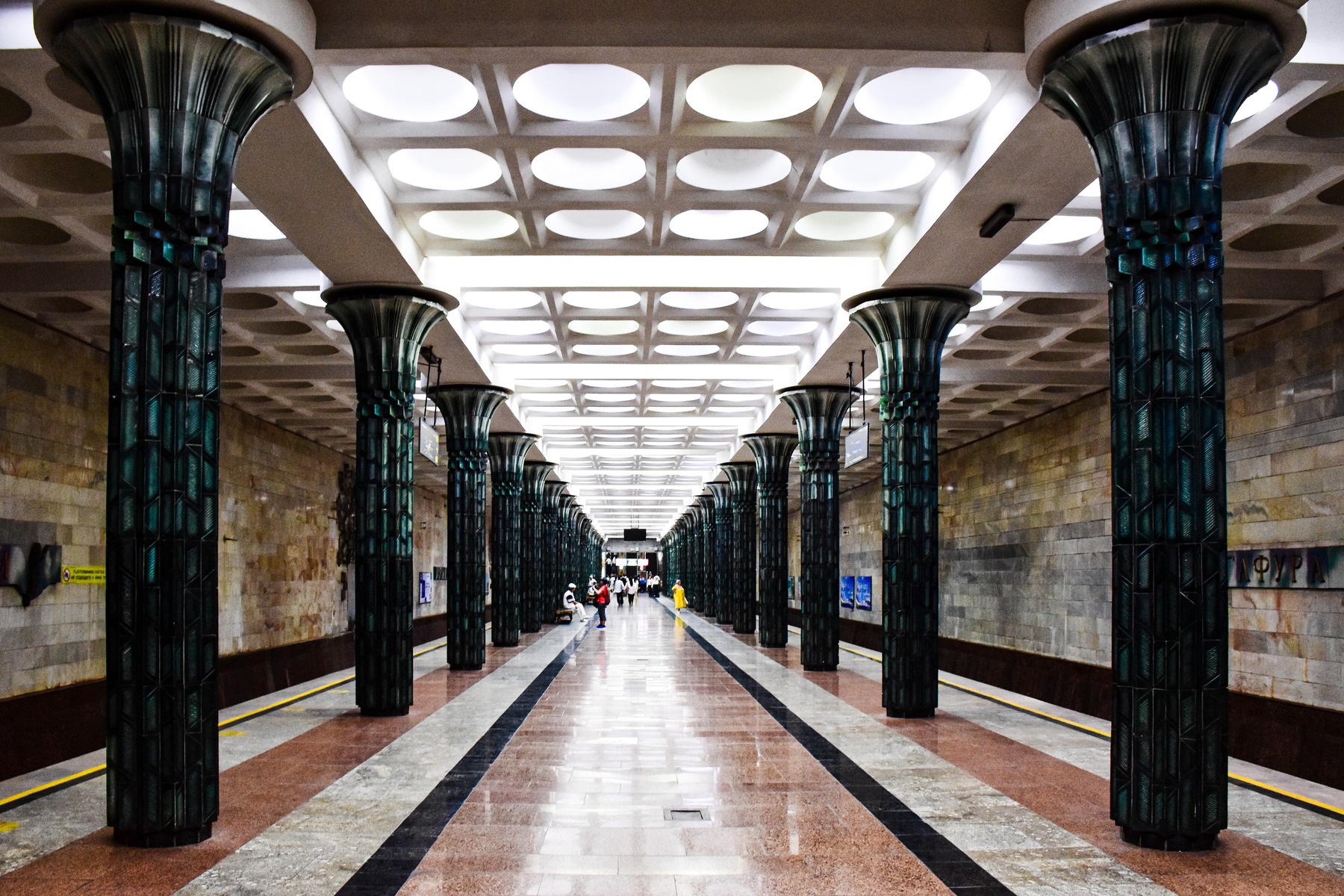 The image shows the column-lined platform at G'ofur G'ulom, one of the Tashkent Metro stations.