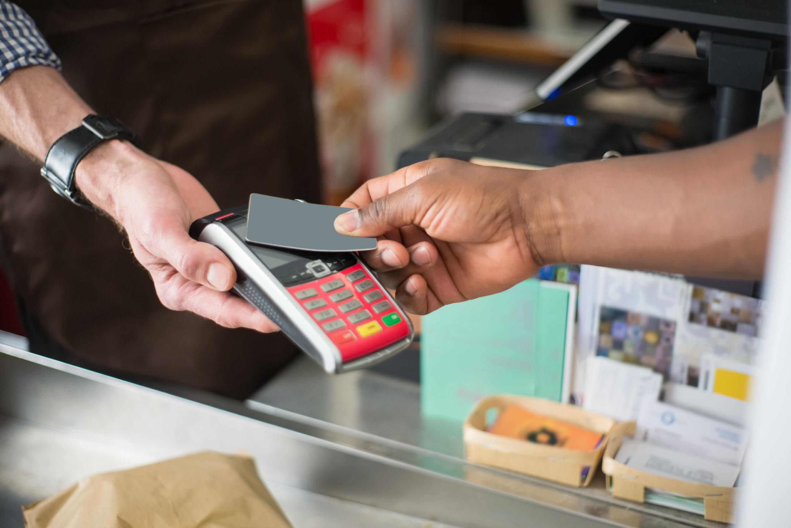 A bank card is held over a contactless payment terminal.