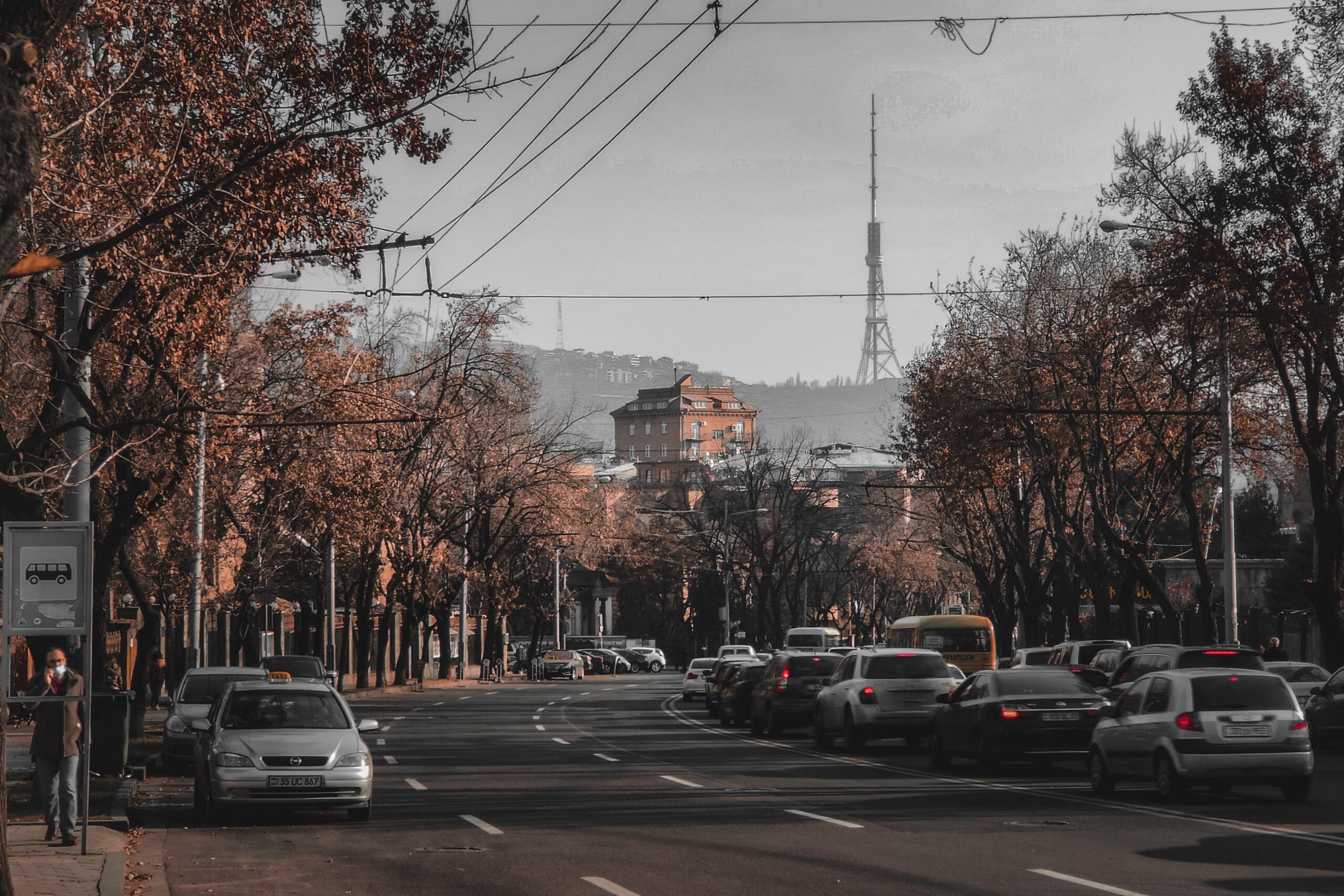 Traffic moves along a central Tbilisi street with the television tower in the background.